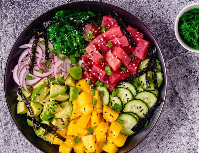 Hawaiian tuna poke bowl with seaweed, avocado, mango, cucumber. Hawaiian tuna poke bowl with seaweed, avocado, mango, cucumber, top view.