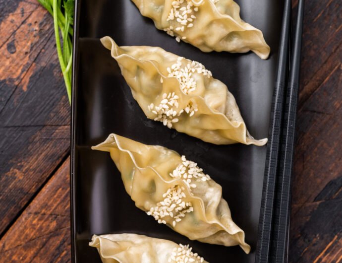 Steamed Korean Dumplings with pork meat and vegetables. wooden b Steamed Korean Dumplings with pork meat and vegetables. wooden background. top view.