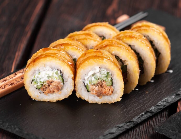 Sushi roll with smoked tuna with cucumber and cheese close-up. Traditional delicious fresh sushi roll set. Sushi menu. Japanese cuisine restaurant. Asian food Sushi roll with smoked eel and salmon with cucumber and cheese. Traditional delicious fresh sushi roll set. Sushi menu. Japanese cuisine restaurant. Asian food.